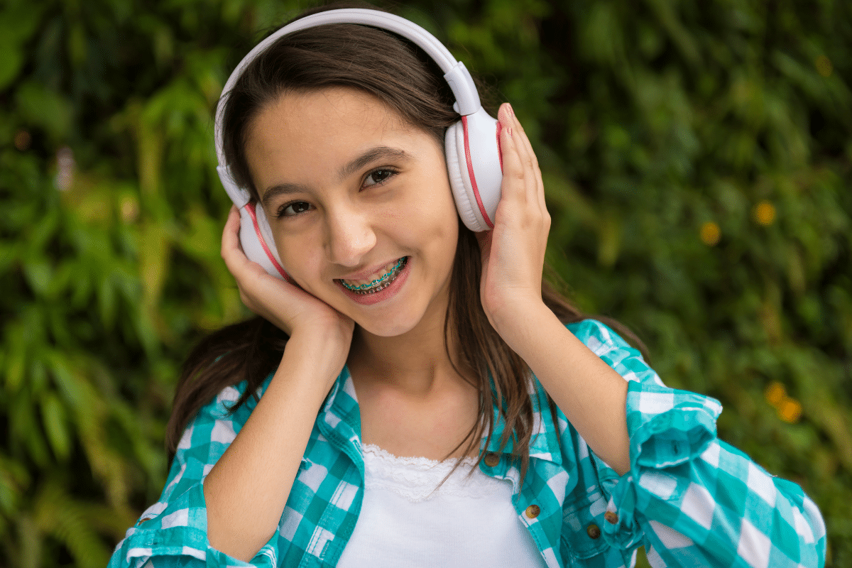 Teen girl smiling with braces while wearing headphones, Beaverton Orthodontics, Beaverton, OR 97007
